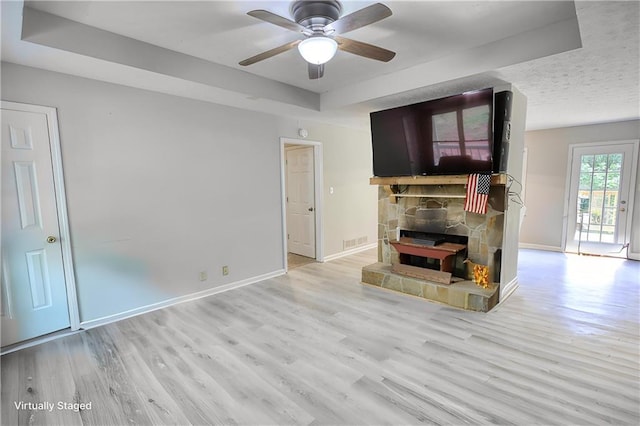 1638 River Trce, Auburn, GA 30011 - unfurnished living room featuring a tray ceiling, ceiling fan, wood finished floors, a fireplace, and baseboards