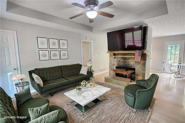 1638 River Trce, Auburn, GA 30011 - living room with a raised ceiling, a ceiling fan, a stone fireplace, and wood finished floors