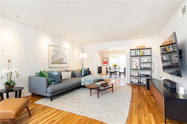 living room with wood-type flooring and a chandelier