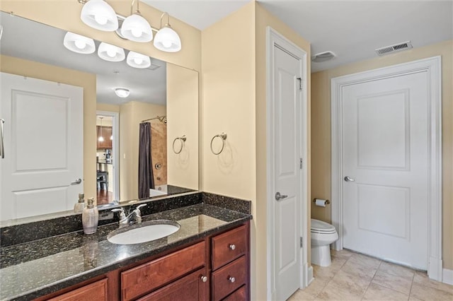 bathroom with tile patterned flooring, vanity, and toilet