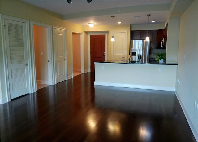 kitchen with decorative light fixtures, dark hardwood / wood-style flooring, dark brown cabinetry, and appliances with stainless steel finishes