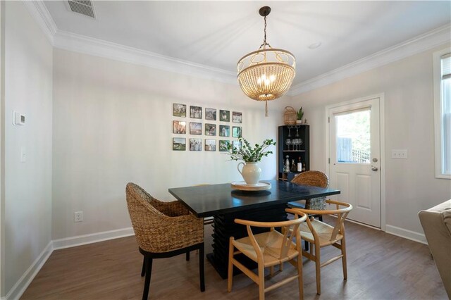 dining room with ornamental molding, dark hardwood / wood-style flooring, and a notable chandelier