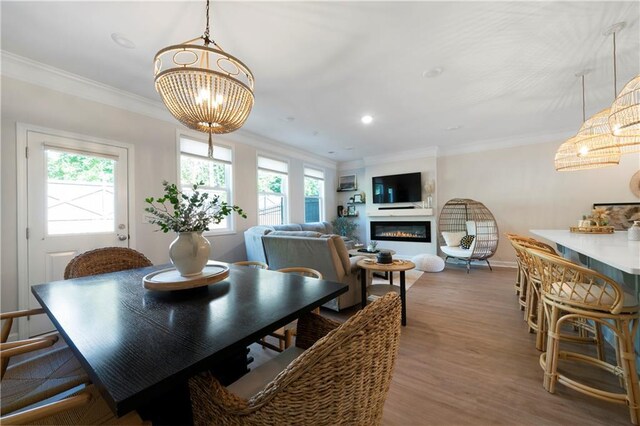 dining area with crown molding, hardwood / wood-style floors, and a notable chandelier