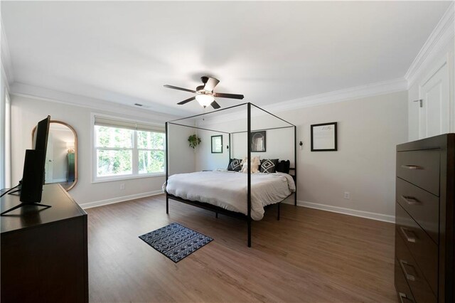 bedroom with crown molding, ceiling fan, and dark hardwood / wood-style flooring