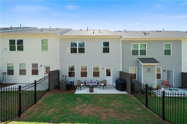 rear view of property with outdoor lounge area, a lawn, and a patio area