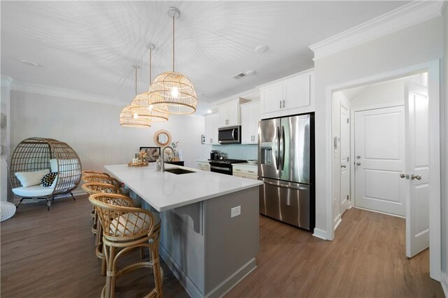 kitchen featuring pendant lighting, stainless steel appliances, sink, and dark hardwood / wood-style floors