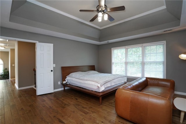 7185 Hartsfield Pl, Suwanee, GA 30024 - bedroom featuring a raised ceiling, baseboards, wood finished floors, multiple windows, and crown molding