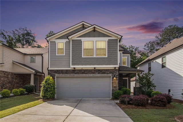 craftsman-style home with concrete driveway, a garage, stone siding, board and batten siding, and a yard