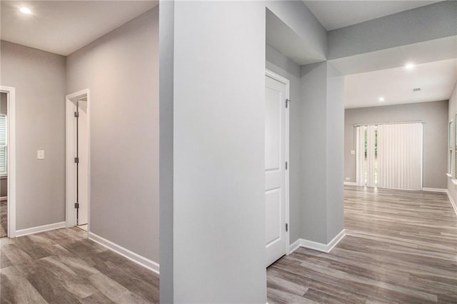 hall with baseboards, recessed lighting, and wood finished floors