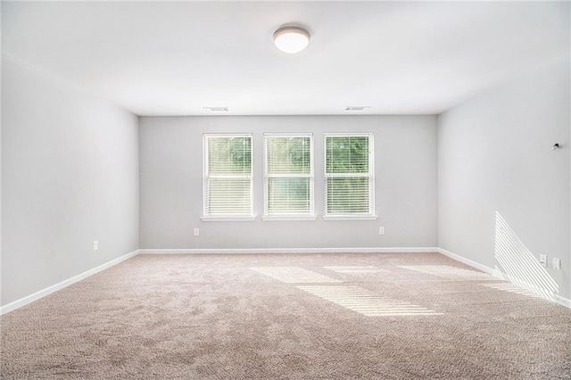unfurnished room with carpet and baseboards