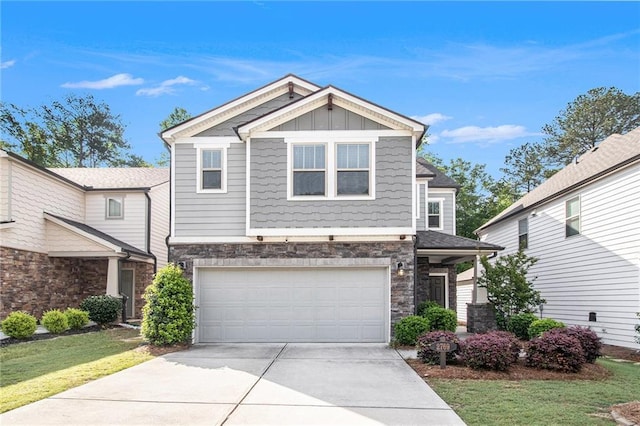 craftsman-style house featuring stone siding, concrete driveway, an attached garage, a front yard, and board and batten siding