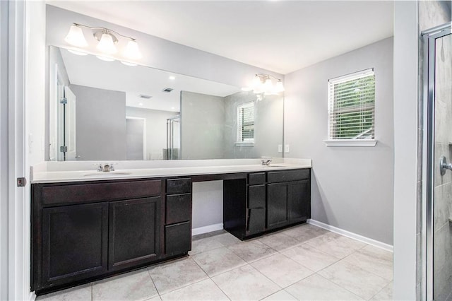 bathroom featuring double vanity, a stall shower, and baseboards