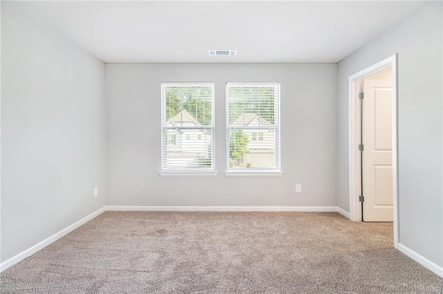 empty room with light colored carpet and baseboards