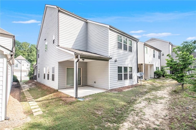 rear view of property featuring a patio and a yard