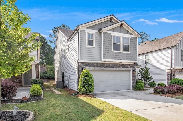 craftsman inspired home with an attached garage, cooling unit, a front yard, driveway, and stone siding