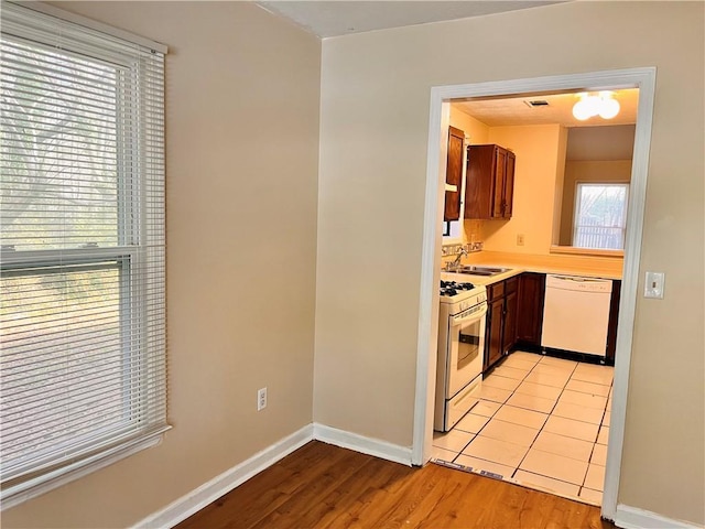 kitchen featuring white appliances, light hardwood / wood-style flooring, and sink