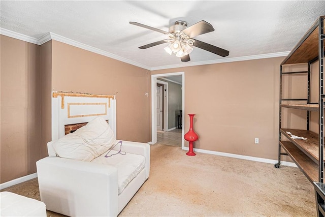 sitting room with ornamental molding, carpet floors, baseboards, and a ceiling fan