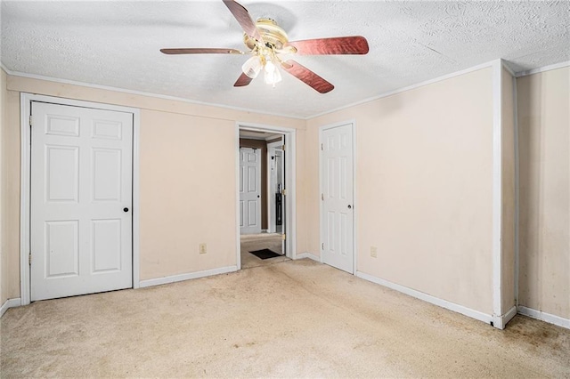 unfurnished bedroom featuring a textured ceiling, ornamental molding, and carpet flooring