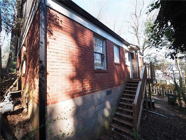 view of side of property with brick siding and crawl space