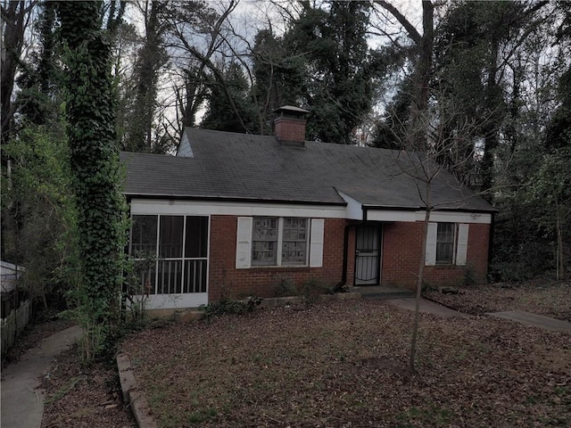 view of front of property with a chimney and brick siding