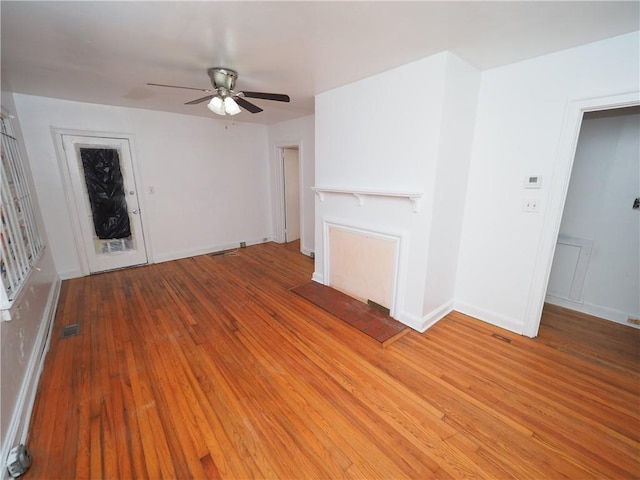 unfurnished living room featuring ceiling fan, visible vents, baseboards, and wood finished floors