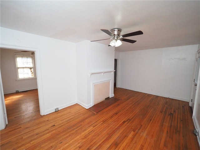 spare room with light wood-type flooring, baseboards, and a ceiling fan