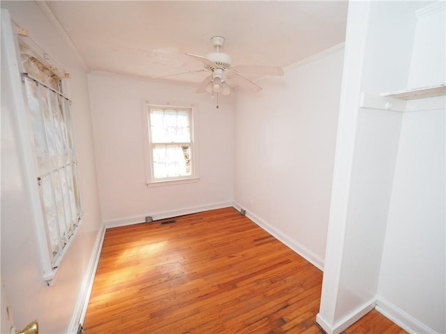 unfurnished room with light wood-style flooring, visible vents, a ceiling fan, baseboards, and ornamental molding