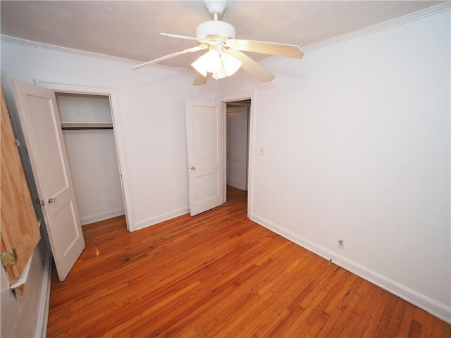 unfurnished bedroom with light wood-style floors, a closet, crown molding, and baseboards