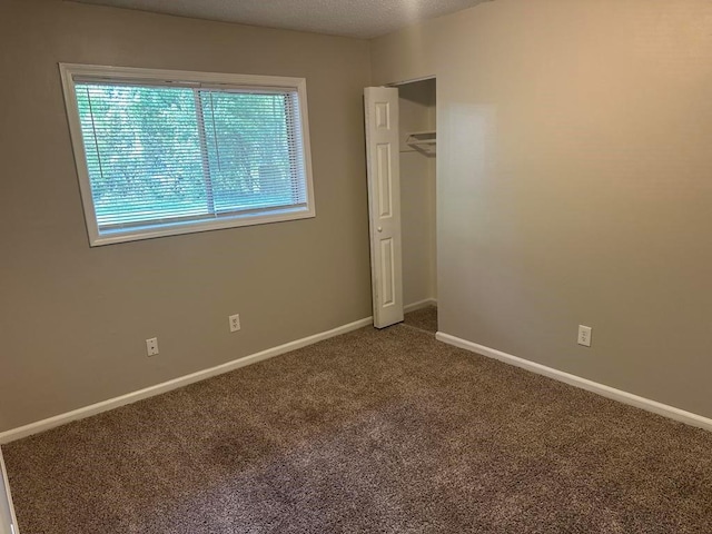 unfurnished bedroom with carpet floors, baseboards, and a closet