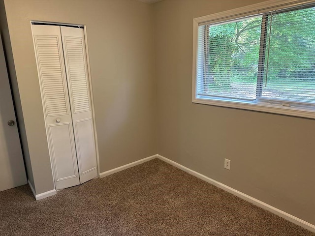 unfurnished bedroom featuring carpet flooring, baseboards, and a closet