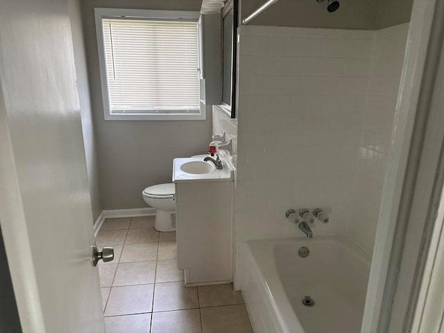 bathroom with vanity, toilet, tile patterned floors, baseboards, and tub / shower combination