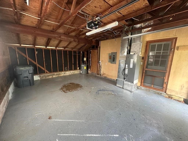 garage featuring a garage door opener, heating unit, and electric panel
