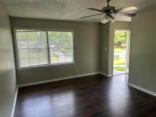 unfurnished room with baseboards, a ceiling fan, a textured ceiling, and dark wood-style flooring