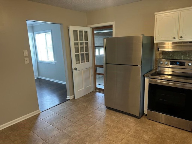 kitchen with baseboards, under cabinet range hood, white cabinets, and stainless steel appliances