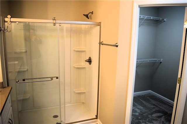 235 Woodland Way, Canton, GA 30114 - full bath featuring a stall shower, vanity, a walk in closet, and baseboards