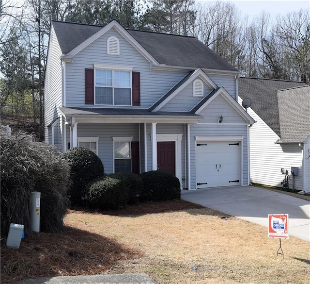 traditional-style home featuring a garage, a front lawn, driveway, and a shingled roof