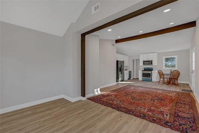 unfurnished living room featuring light hardwood / wood-style floors and lofted ceiling with beams