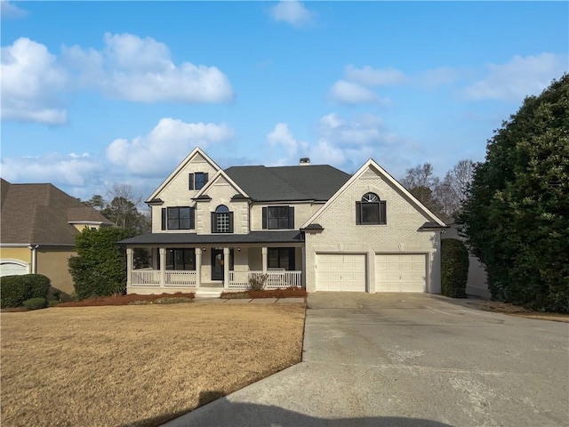 view of front of home with covered porch, a garage, and a front lawn