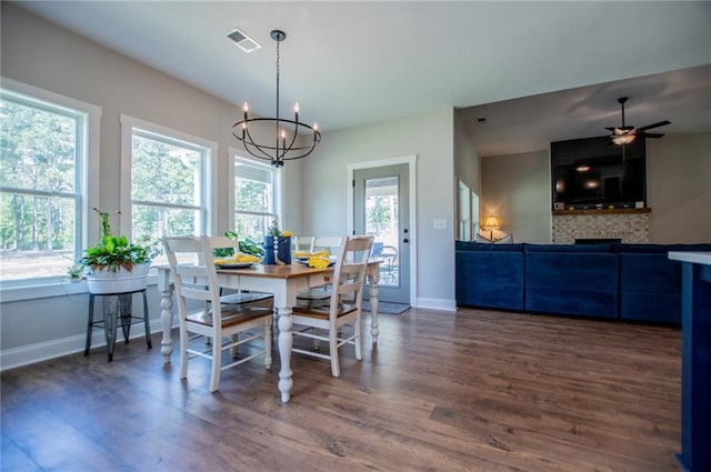 dining room with a healthy amount of sunlight, dark hardwood / wood-style flooring, and ceiling fan with notable chandelier