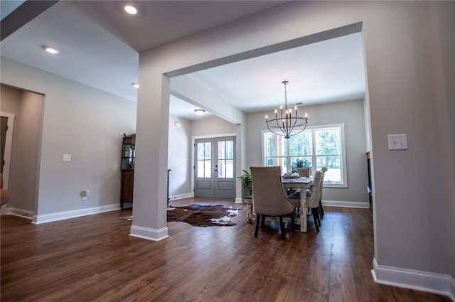 dining room with dark wood-type flooring, french doors, and a chandelier