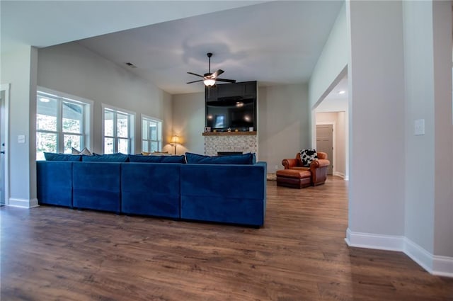 living room featuring dark wood-type flooring and ceiling fan