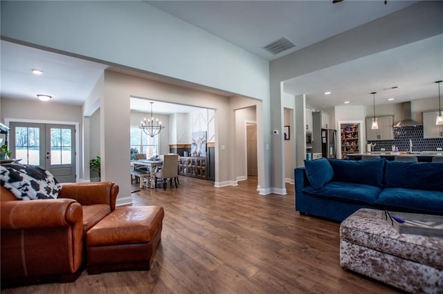 living room with french doors, dark hardwood / wood-style floors, and an inviting chandelier