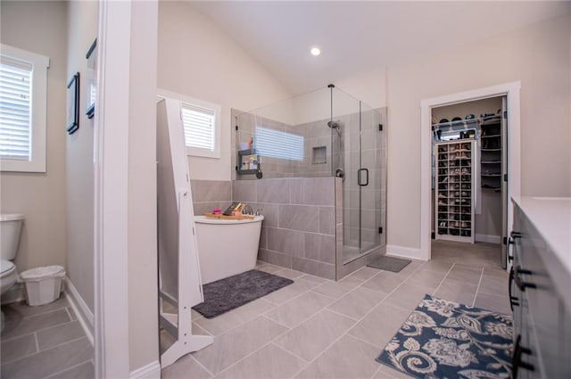 bathroom with tile patterned flooring, vaulted ceiling, toilet, and walk in shower