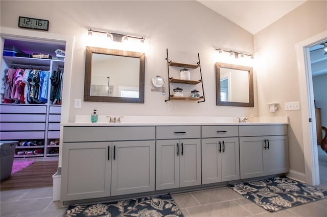 bathroom featuring vanity, tile patterned flooring, and vaulted ceiling