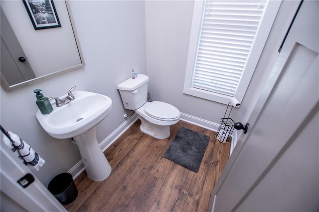 bathroom featuring wood-type flooring and toilet