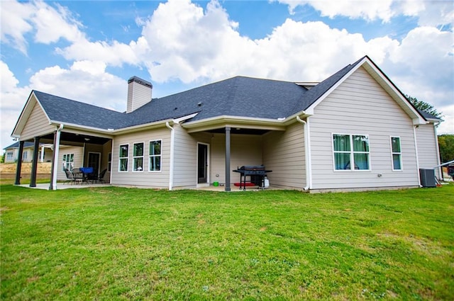 back of house with central air condition unit, a patio area, and a lawn