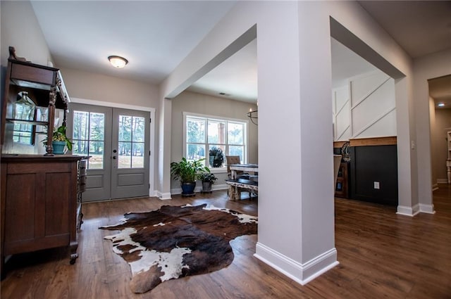 entrance foyer featuring dark wood-type flooring, french doors, and a notable chandelier