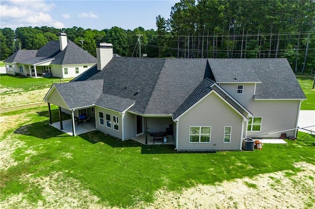 back of property featuring a lawn and a patio