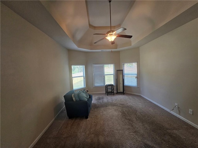 sitting room featuring a tray ceiling, baseboards, carpet, and healthy amount of natural light