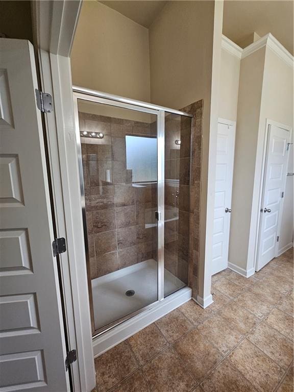 full bath featuring a stall shower, baseboards, and crown molding